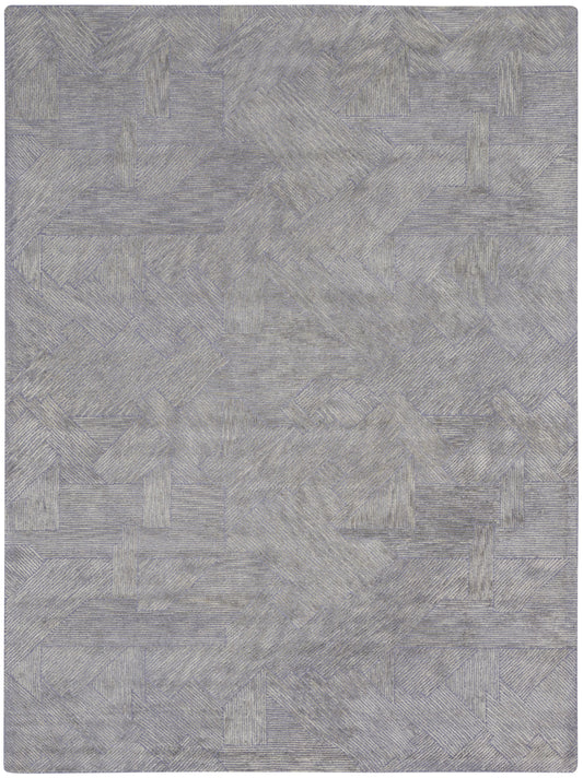 Gray-blue geometric patchwork rug with textured linear patterns; soft, modern area rug for living spaces.