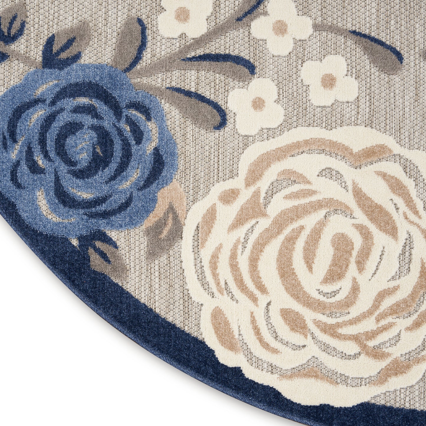Round floral rug with blue & cream roses on a beige woven backdrop & a dark blue border.