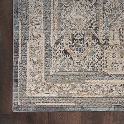 Blue and ivory distressed oriental rug with geometric medallion border on dark wooden floor
