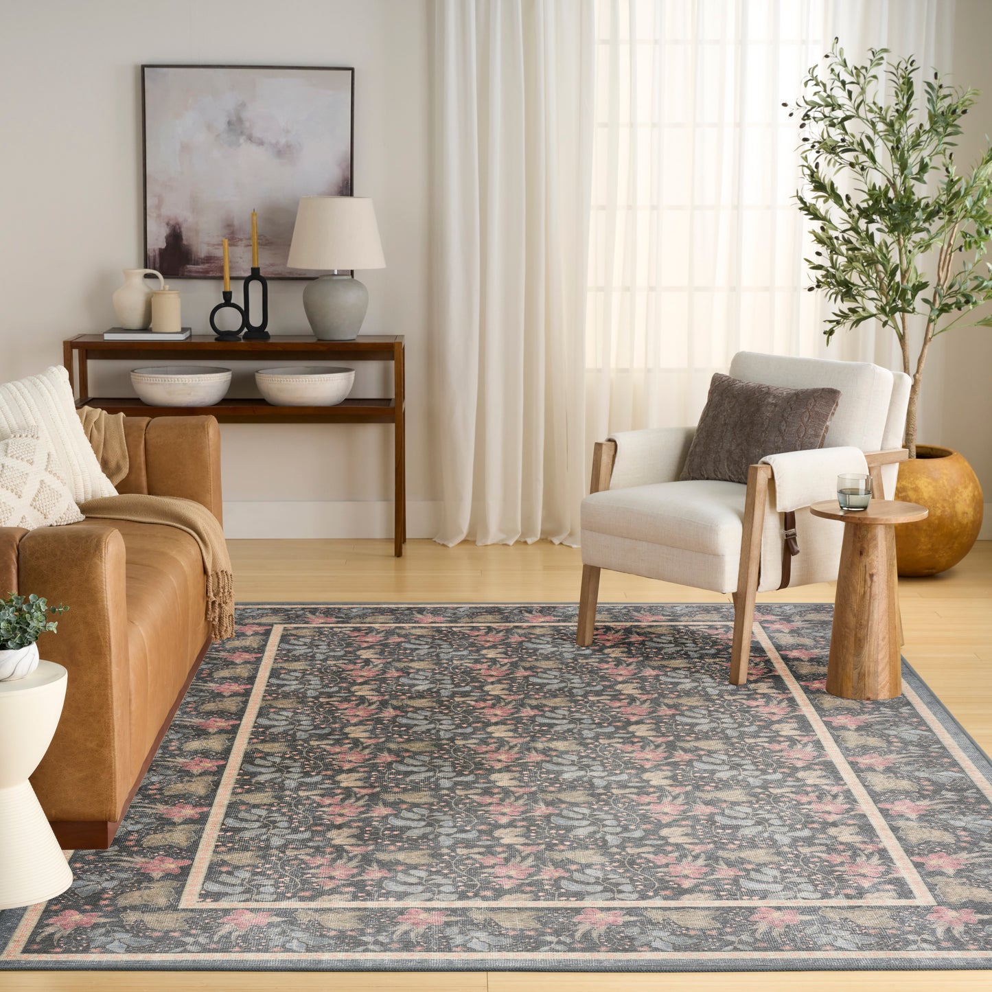 Cozy living room with blue-gray floral rug, brown leather sofa, beige armchair, wooden console table, tall plant