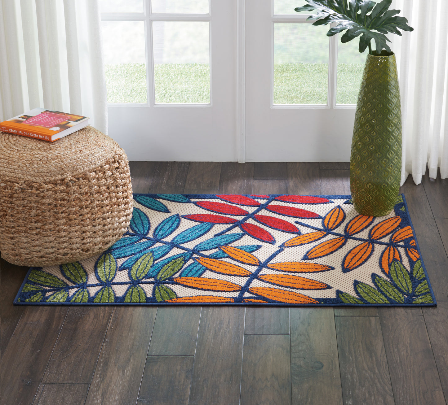 Rectangular colorful rug with blue, orange and green leaves on white; tropical modern motif for living space.