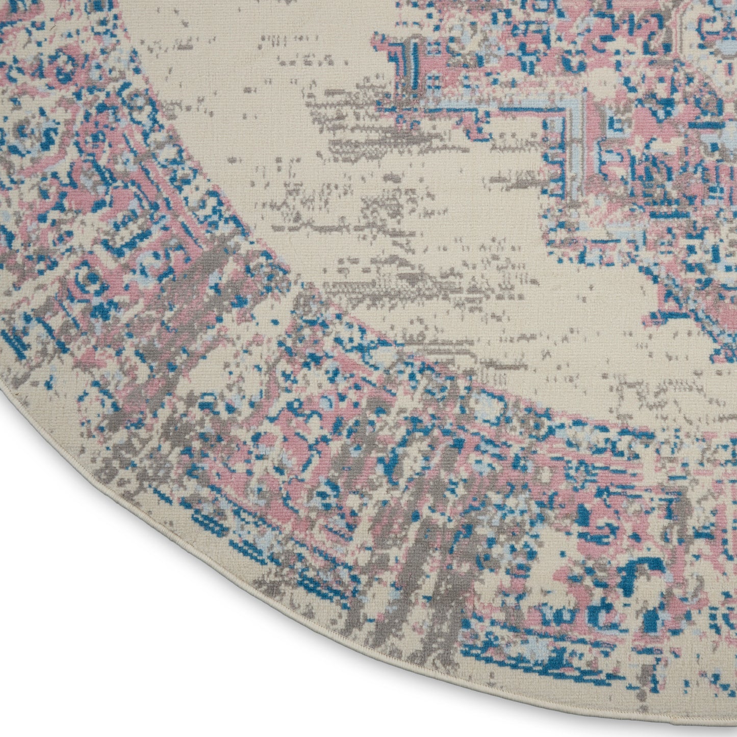Round vintage-style rug with distressed pink, blue & beige medallion pattern & woven texture.