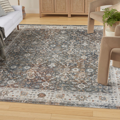 Traditional blue-gray rug with cream medallions on light hardwood, paired with beige upholstered chairs.