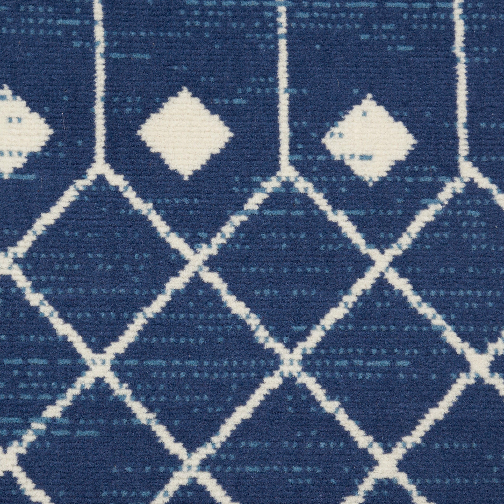 Navy blue woven rug with white diamond lattice pattern; geometric, modern boho home decor.
