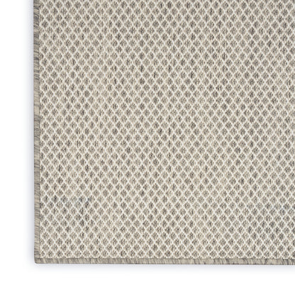 Soft beige rug with cream woven fringe along the bottom edge, in a simple modern style.