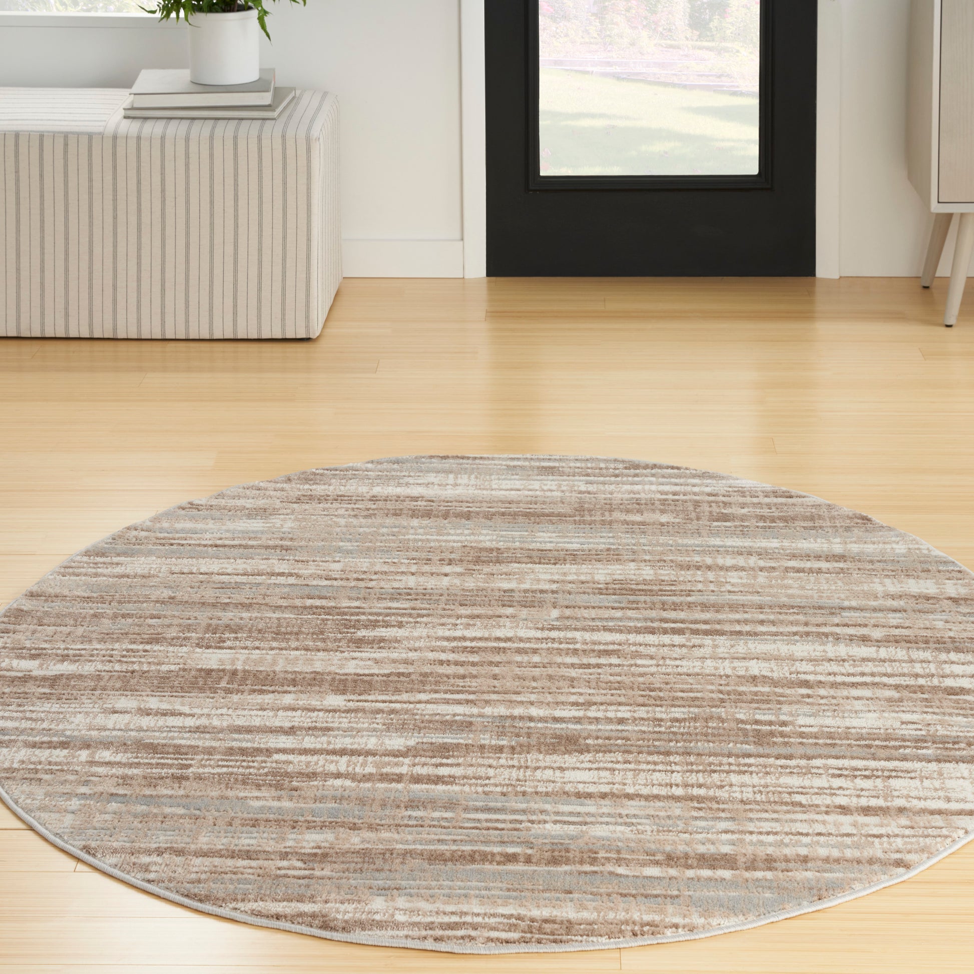 Round striped beige & brown area rug on light wood floor in modern living room