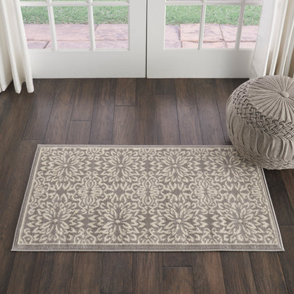 Cream & beige damask floral flat-weave rug, rectangular, on dark wood flooring near glass doors.