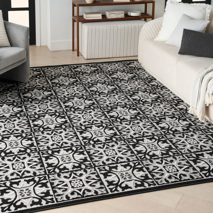 Rectangular black-and-white ornate patterned woven rug in a modern living room.
