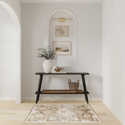 Dark wood console table in a light alcove with arched niche; vase of branches, basket, framed art, and beige patterned rug.