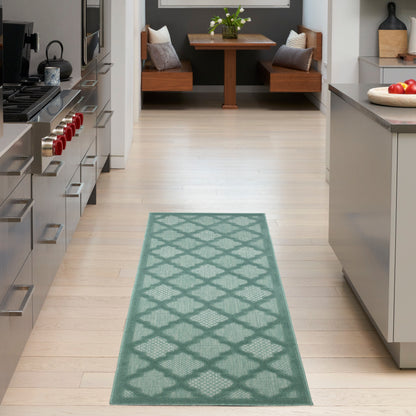 Teal lattice-pattern rug runner in a bright modern kitchen with light wood floor and stainless appliances.