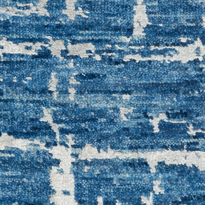 Close-up of a blue-toned shag rug with white abstract lines; plush texture and modern geometric style.