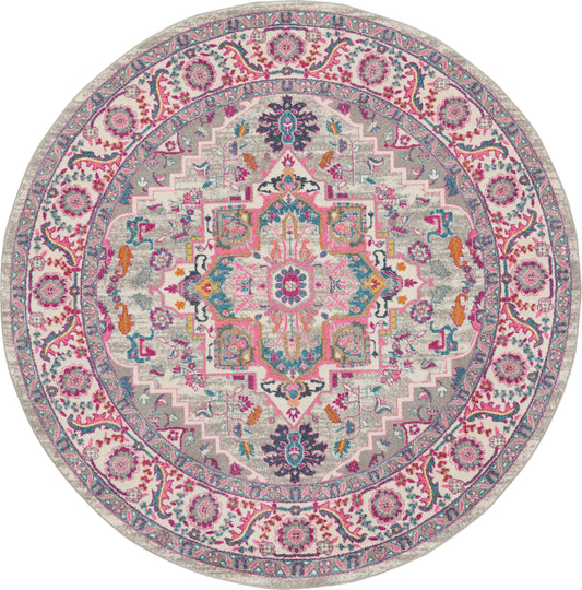 Round oriental rug in pink, teal and cream with central medallion and floral border; vintage-inspired decor.
