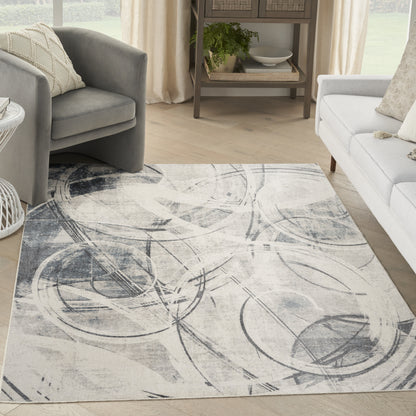 Abstract gray & cream area rug with circular swirl patterns in a light, modern living room.