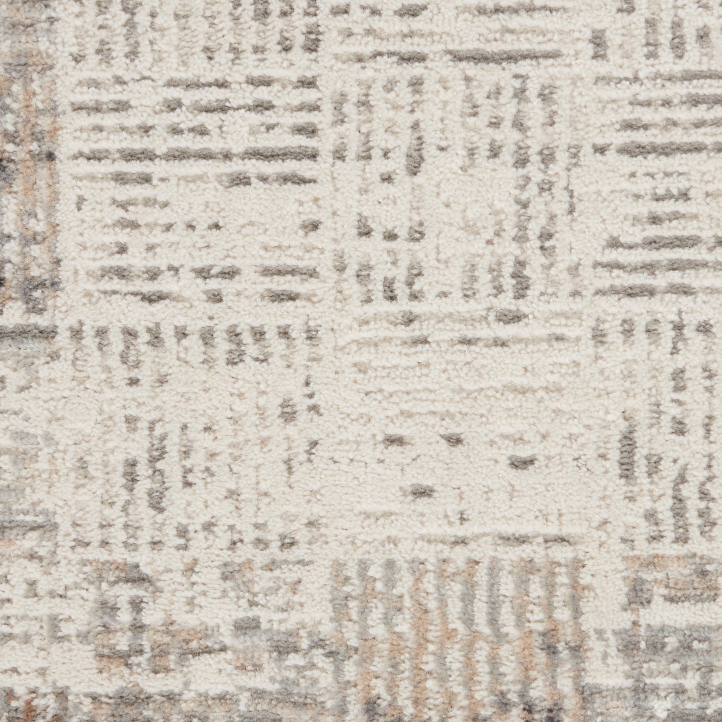 Neutral beige and taupe patchwork area rug with subtle geometric grid pattern and soft textured pile.