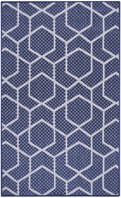 Navy blue rectangular rug with white geometric hex pattern; woven texture, modern floor decor.