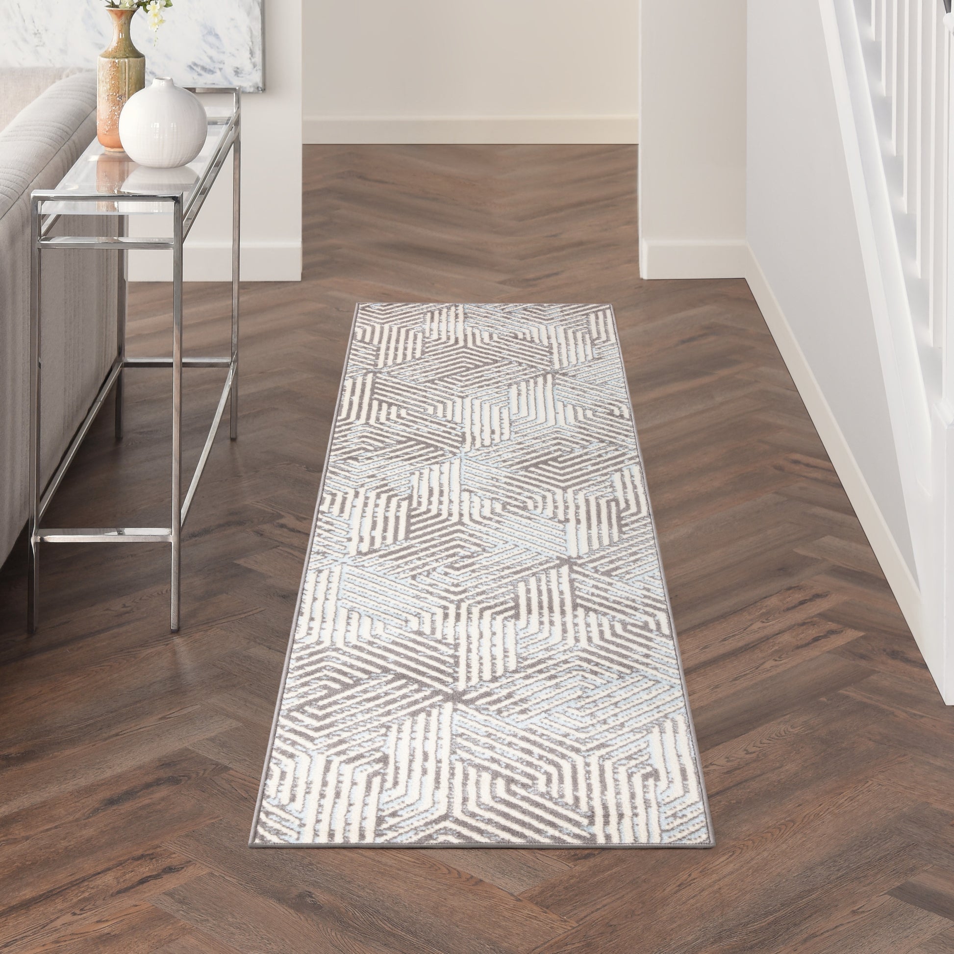 Long gray-and-white geometric hallway runner rug with chevron/hex pattern in a modern entryway.