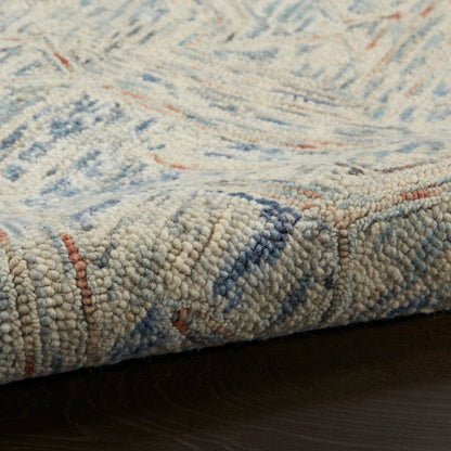 Plush loop-pile rug in cream with blue & rust accents; wool-like texture, geometric pattern, rectangular.