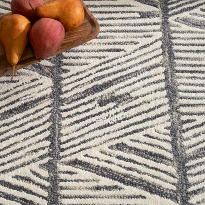 Brown wooden tray with orange-red pears sits on a cream and charcoal geometric woven rug.