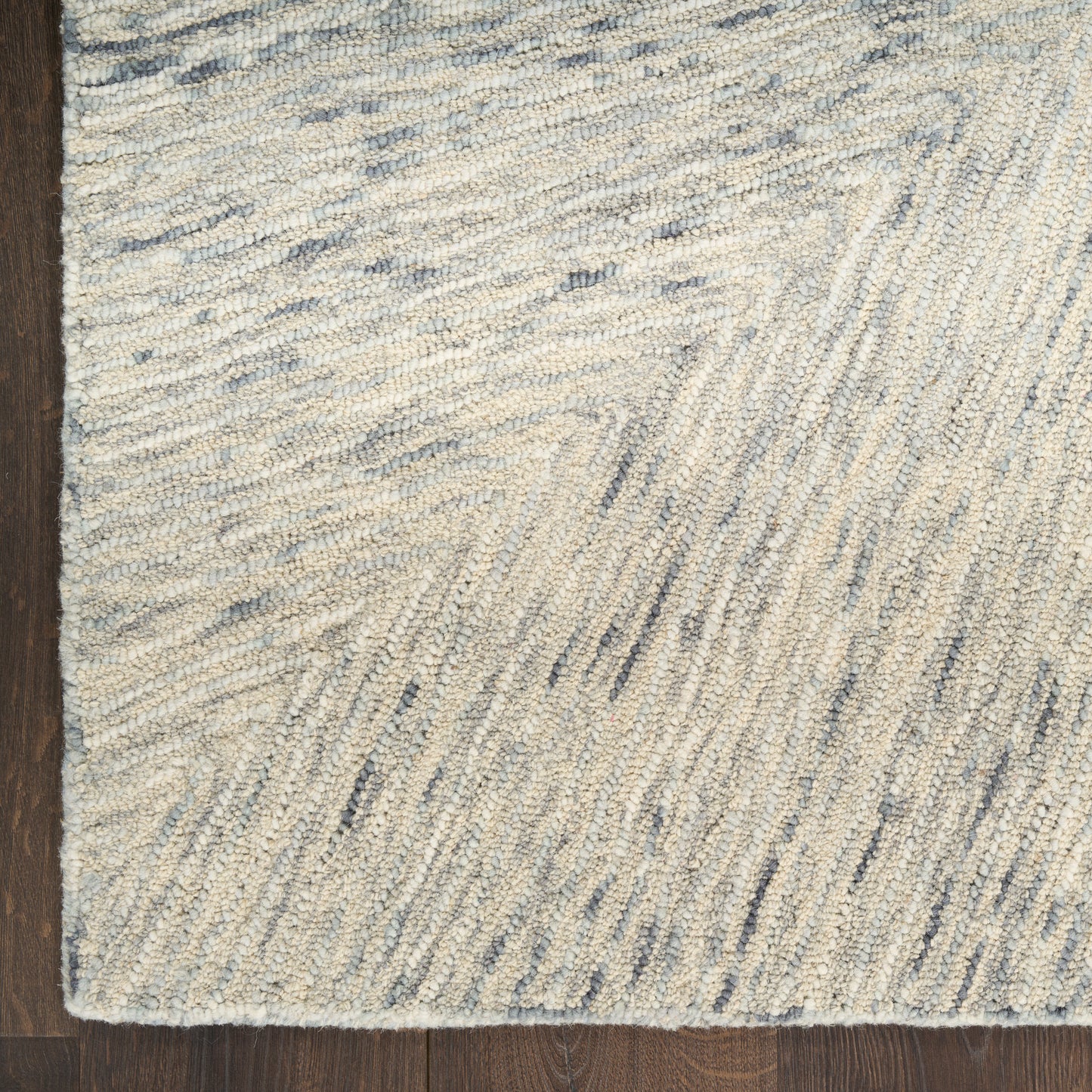 Cream and pale blue shag rug with subtle wavy stripes on a dark wooden floor.
