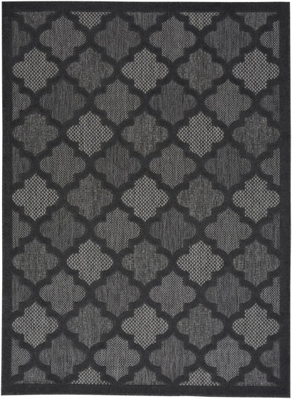Dark charcoal and black geometric rug with repeating trellis pattern; woven surface, modern indoor accent.