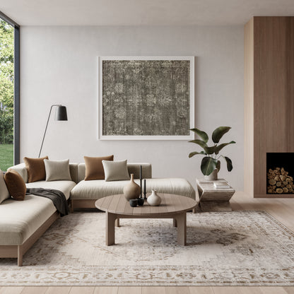 Neutral-toned living room with a vintage 8' x 10' rug, beige sectional, round wood coffee table, abstract art, tall floor lamp, and a plant.