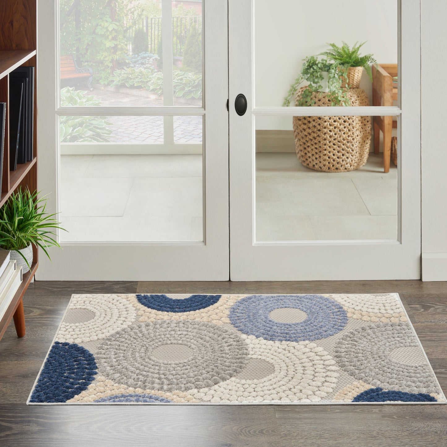 Rectangular entry rug with concentric circle rosettes in cream, beige, gray and navy; textured woven design.
