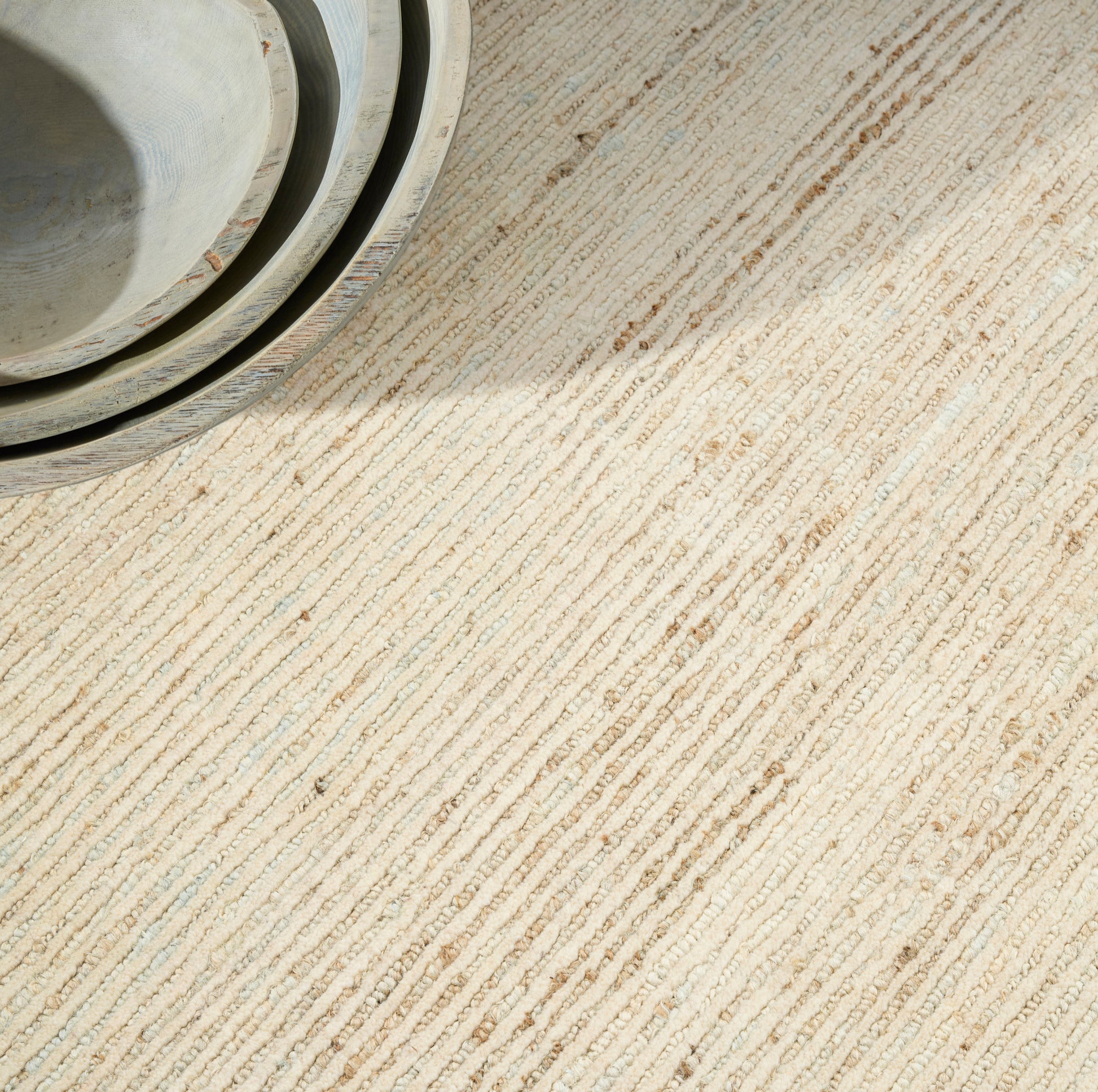 Beige textured rug with light gray-blue tones.