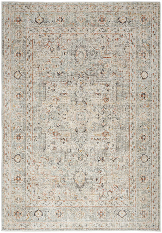 Muted ivory-gray area rug with distressed oriental pattern, pale blue accents, central medallion, floral border.