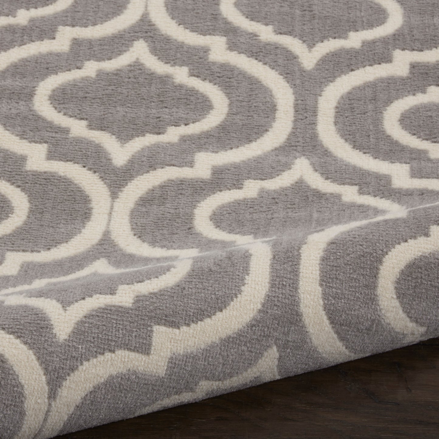 Gray runner rug with a white trellis pattern and plush texture, featuring a modern geometric design.