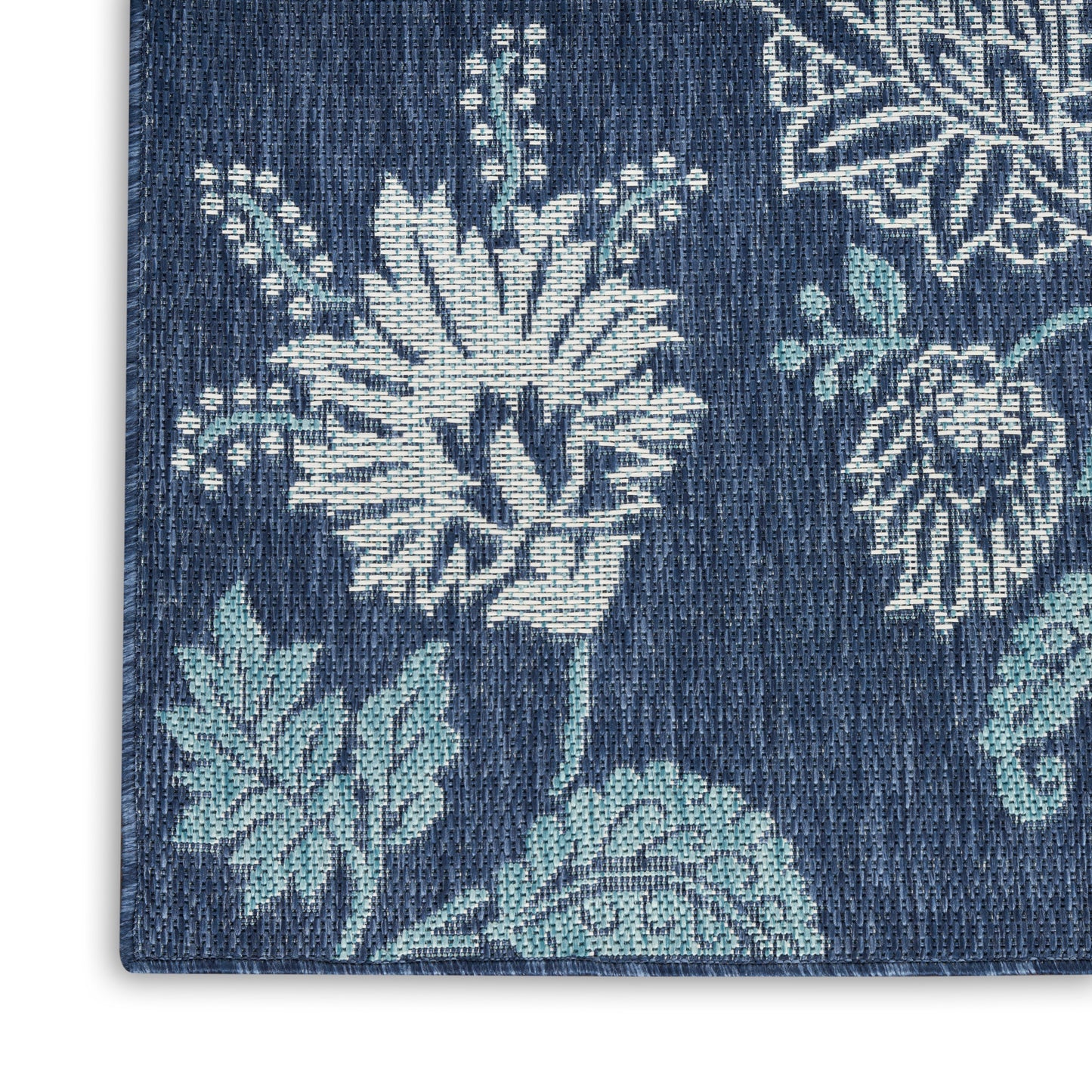 Dark blue rug with white and light teal floral motifs in a denim-like weave