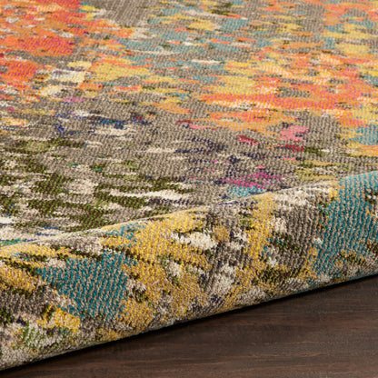 Vibrant multicolor abstract woven rug with geometric patterns, folded edge on dark wood floor.