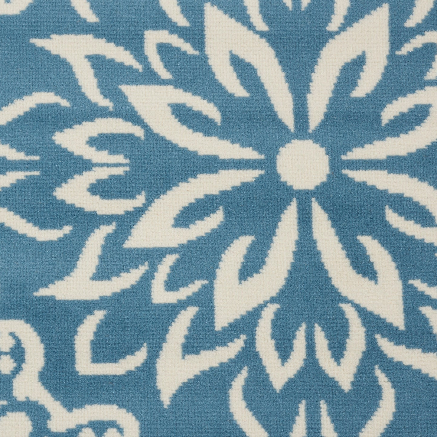 White floral pattern on blue fabric; woven textile with bold, symmetrical petals for decorative upholstery or home decor.
