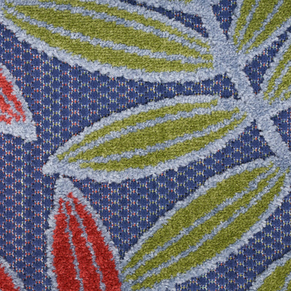 Close-up of a textured rug with olive-green leaf motifs outlined in light blue on a navy loop-pile background.