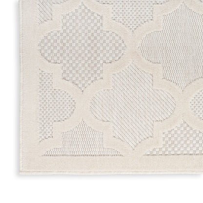 Cream rug close-up with raised quatrefoil lattice pattern and textured weave.