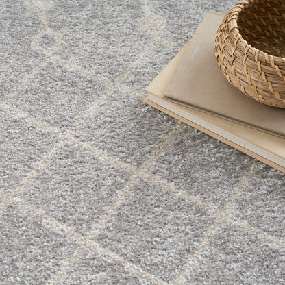 Soft grey shag rug with pale beige diamond lattice, stacked beige notebooks, and a round woven basket.