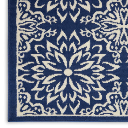 Blue rug with white intricate floral/mandala pattern and border, woven textile for living room decor.
