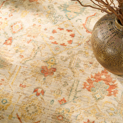 Cream oriental rug with pastel floral motifs in orange, blue & yellow.