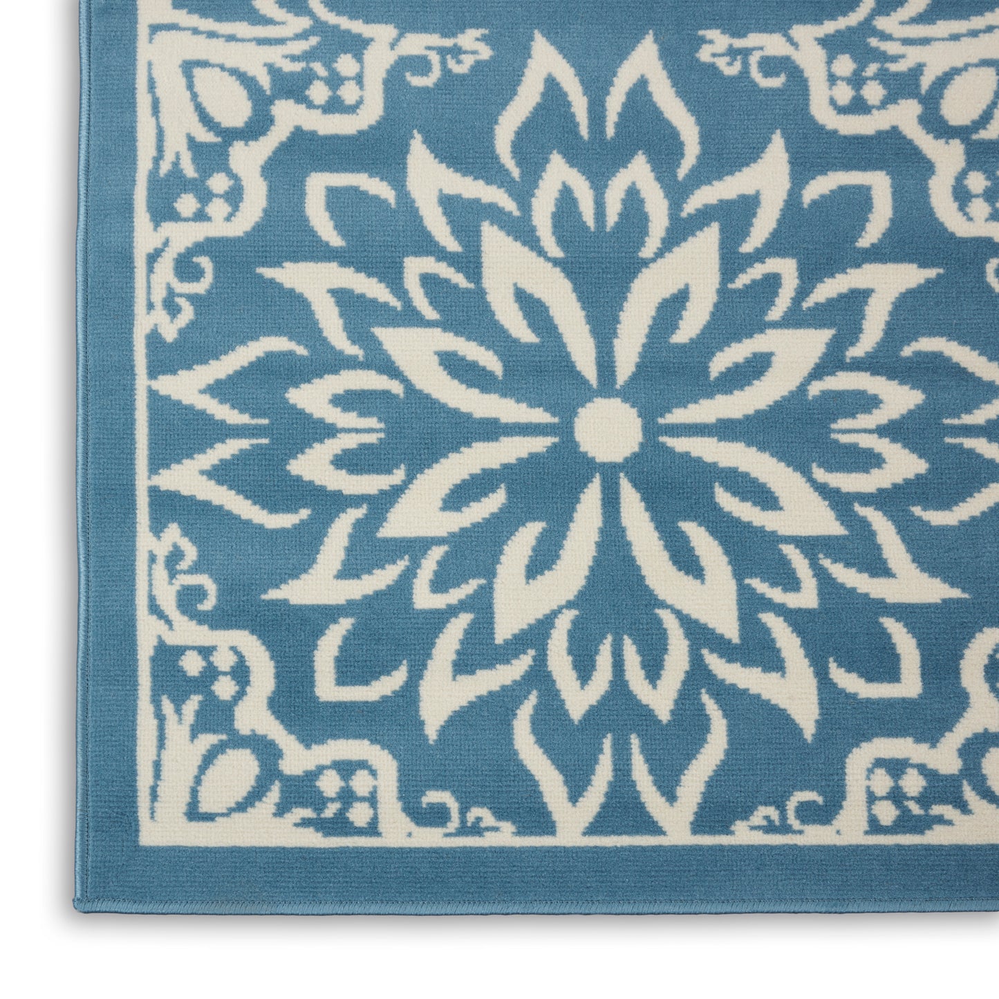 Turquoise textile with white mandala-style floral motif and decorative border; towel or rug.