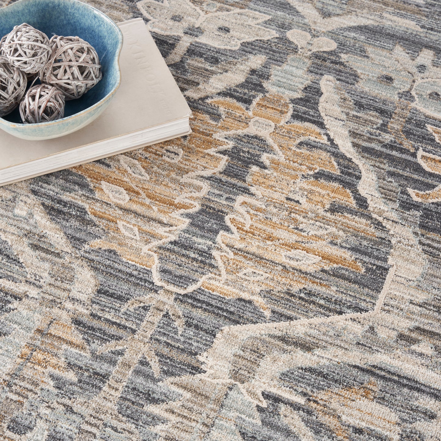 Abstract patterned round rug in blue, gray, and tan hues with plush textured pile for cozy living room decor.