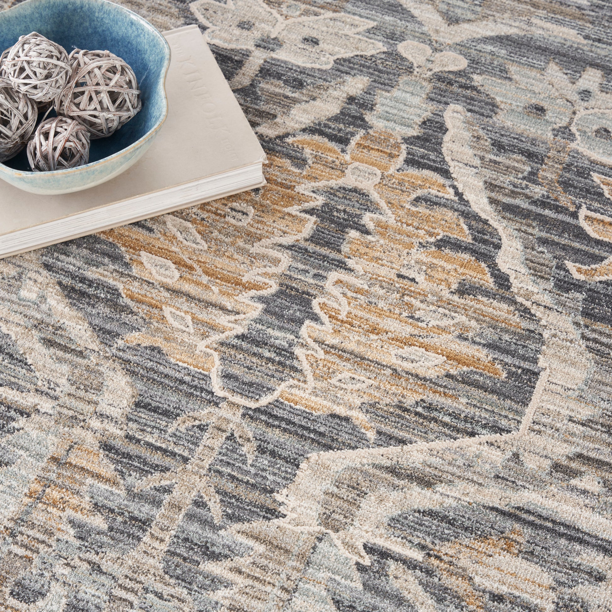Abstract patterned round rug in blue, gray, and tan hues with plush textured pile for cozy living room decor.
