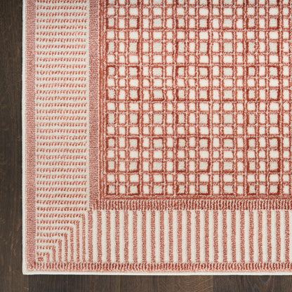 Red & ivory woven rug with a square grid pattern & striped border on dark wood floor