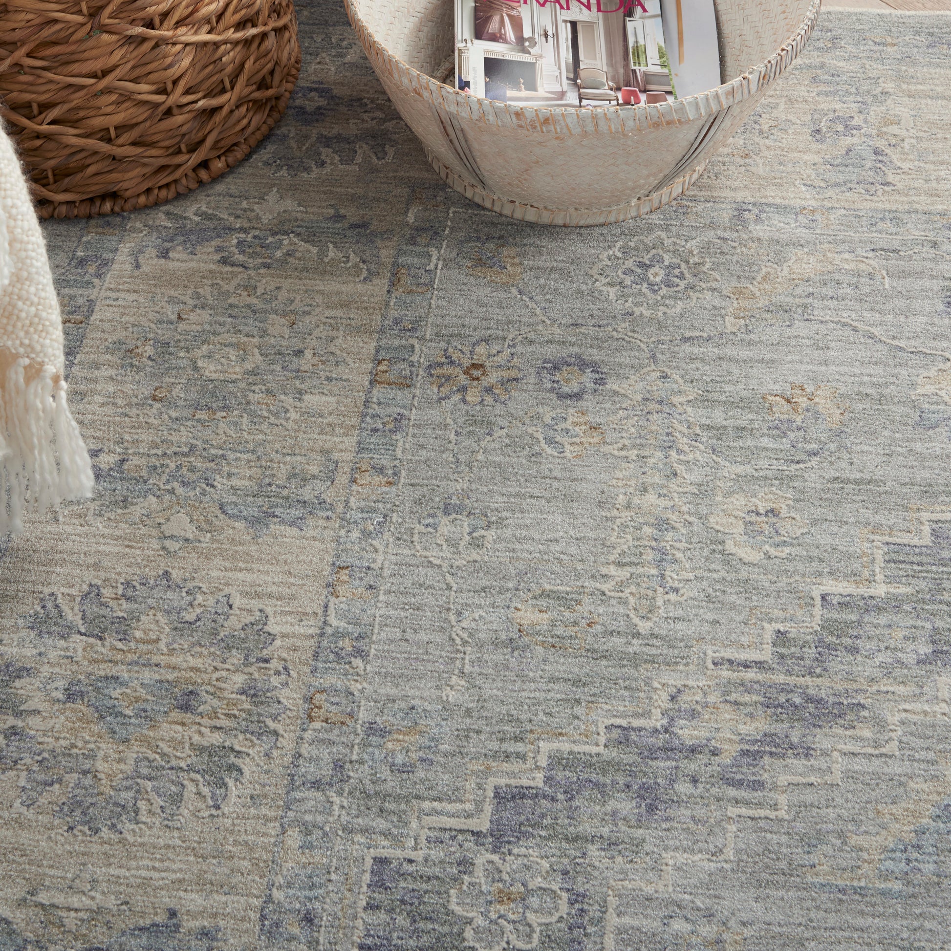Blue-gray distressed oriental rug with faded floral medallions and stepped geometric border.