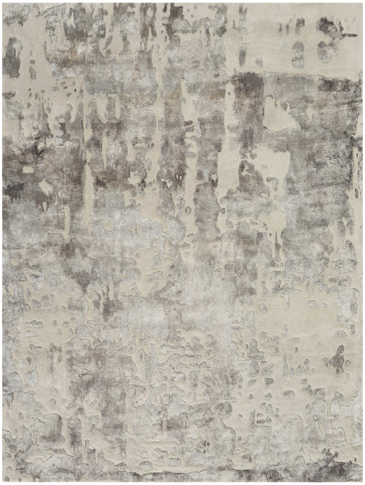 Rectangular area rug with abstract distressed beige and gray patchwork, modern style.