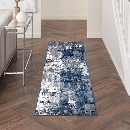Blue and white abstract runner rug with a blue border in a narrow hallway, modern decor with a metal console.