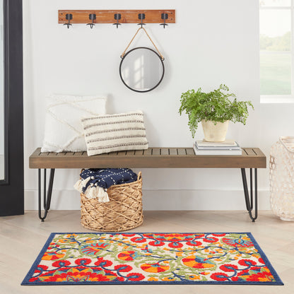 Wood bench with black hairpin legs, white cushions, round wall mirror, potted plant, woven basket, & a colorful rug.