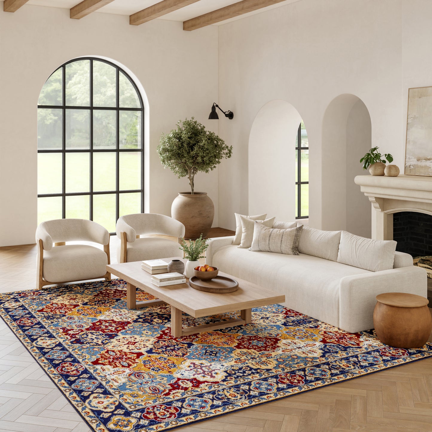 Neutral living room with cream sofa, light wood coffee table, and vibrant Bohemian rug under arched windows.