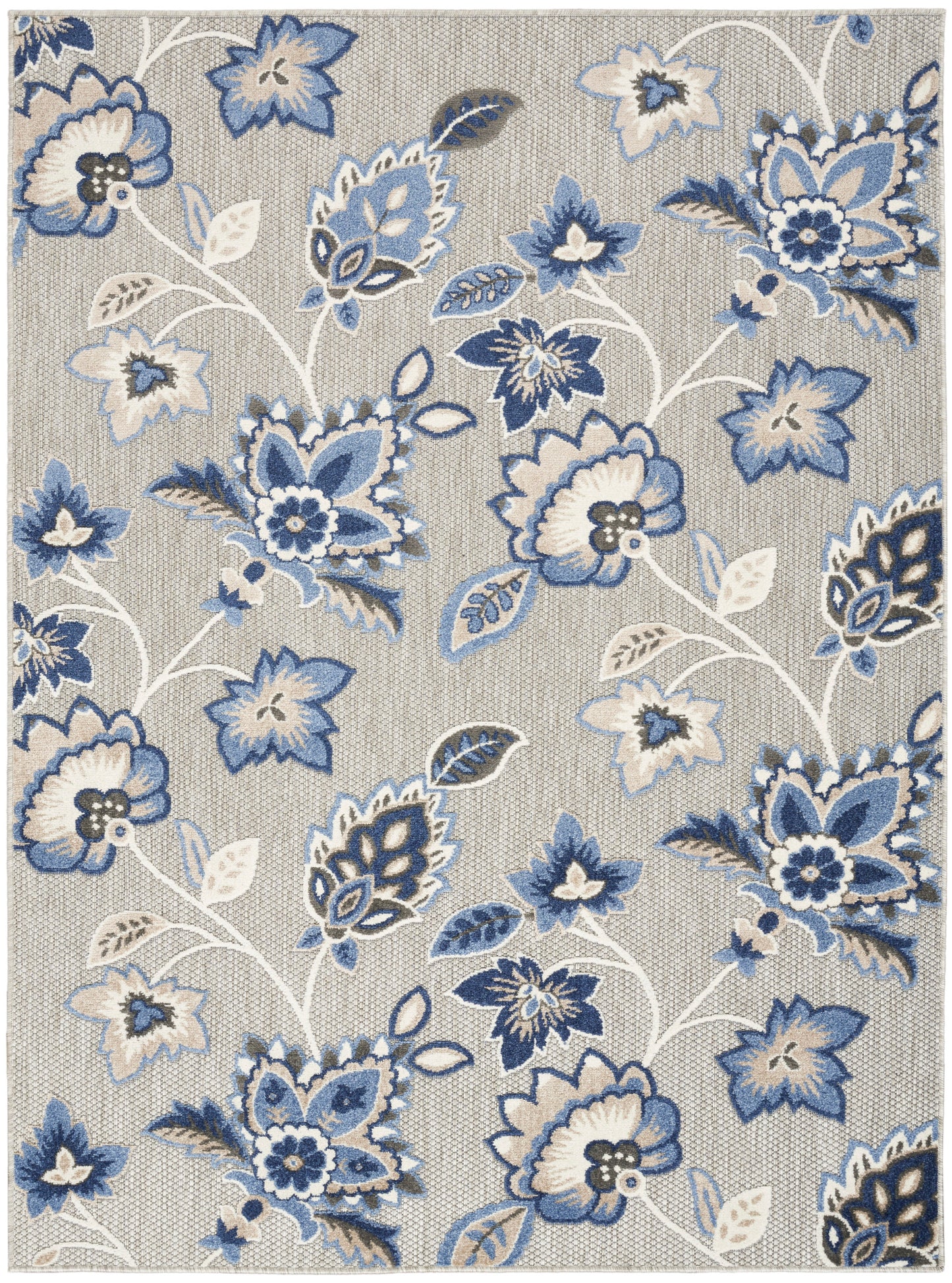 Rectangular beige rug with blue and white floral pattern; large blossoms and curling vines, woven texture.