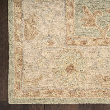 Cream and pale blue floral area rug with pastel border on dark wood floor, textured pile