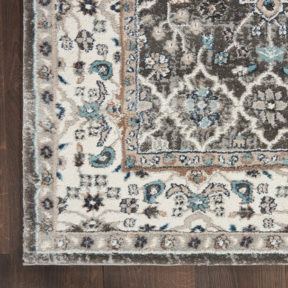 Traditional oriental-inspired rug with cream and gray-brown center, blue floral motifs and beige border on a wooden floor.