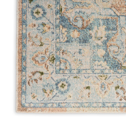 Distressed blue oriental area rug with floral motif and beige border; cropped corner shows soft pile.